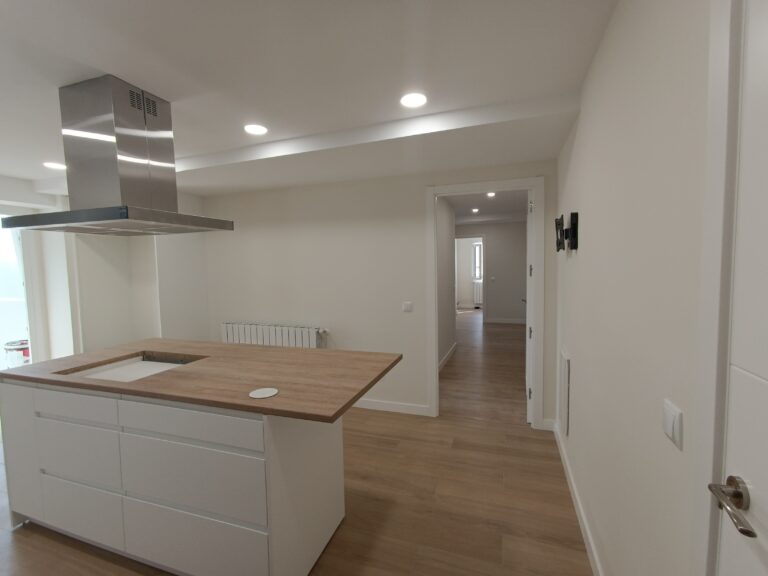 Cocina blanca con isla y encimera de madera