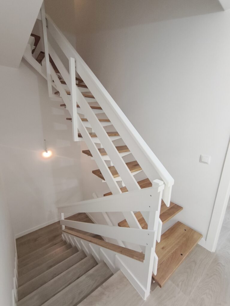 Escalera de chalet con peldaños de madera y tramo de porcelánico