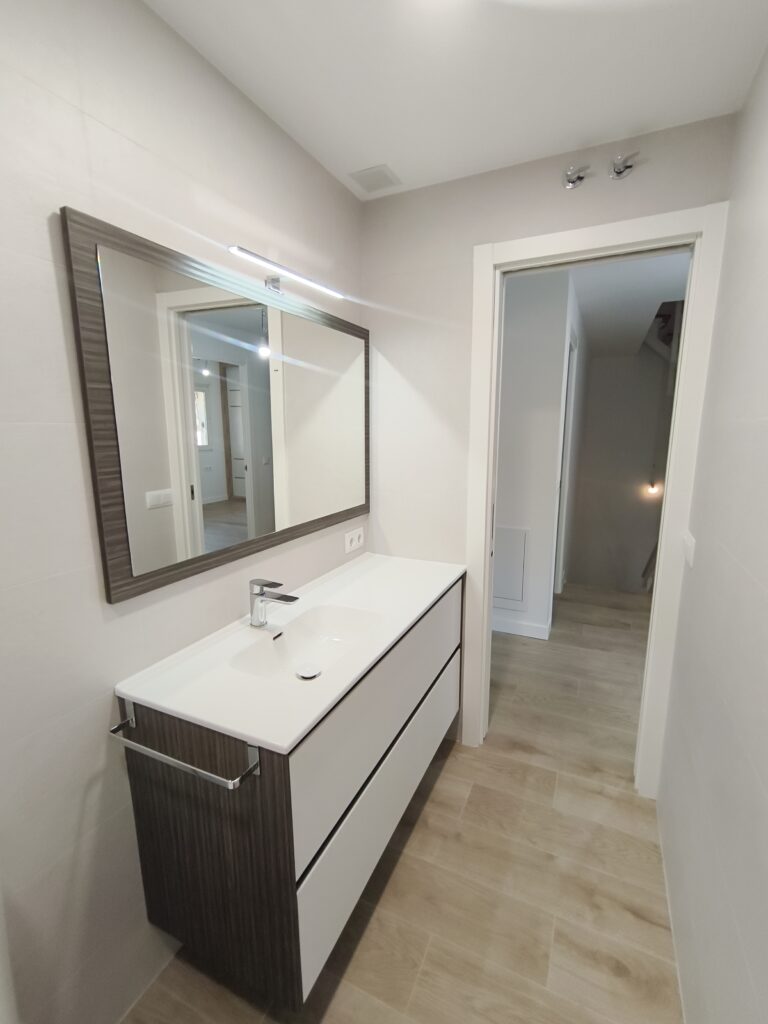Baño reformado con mueble y espejo