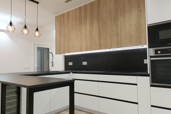 honrado-reforma-cocina-madera-encimera-negra Cocina reformada con armarios altos de madera, muebles blancos y encimera negra